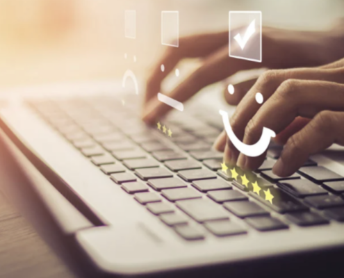 Hands typing on a laptop keyboard with an overlay of smiley faces and star ratings, symbolizing enhanced customer service through IVR systems implemented by a business continuity consultant in Dallas.